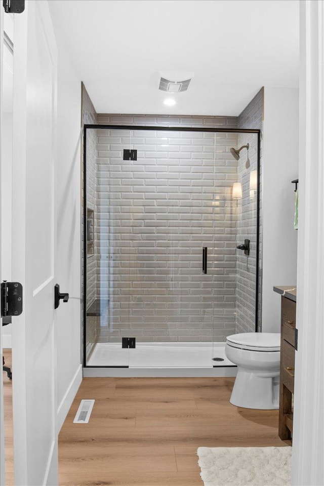 2041 Oak St, Lake City, MN 55041 - bathroom with wood finished floors, visible vents, a shower stall, and toilet