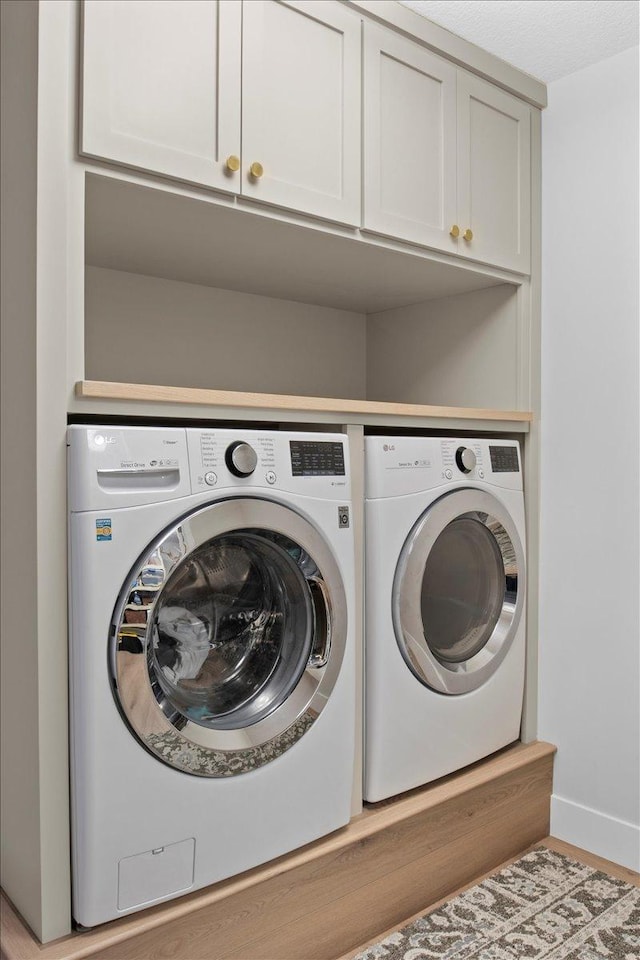 2041 Oak St, Lake City, MN 55041 - laundry room with baseboards, cabinet space, and washer and clothes dryer