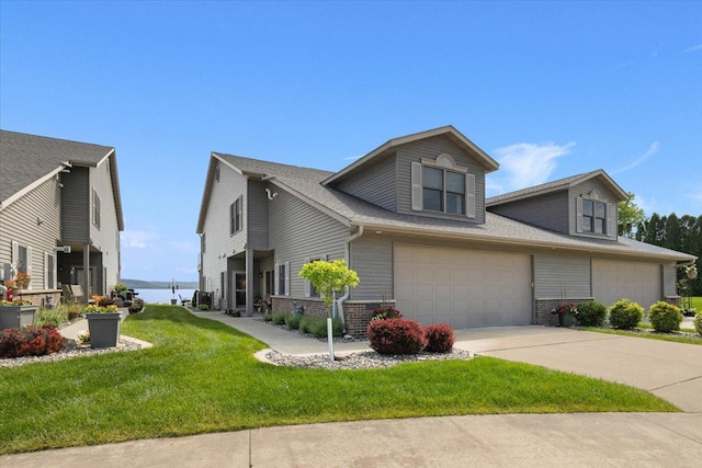 2041 Oak St, Lake City, MN 55041 - view of property exterior with a garage, concrete driveway, a yard, brick siding, and a shingled roof