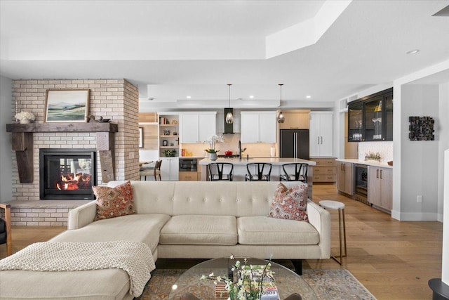 2041 Oak St, Lake City, MN 55041 - living room with wine cooler, light wood-style flooring, recessed lighting, a brick fireplace, and a dry bar