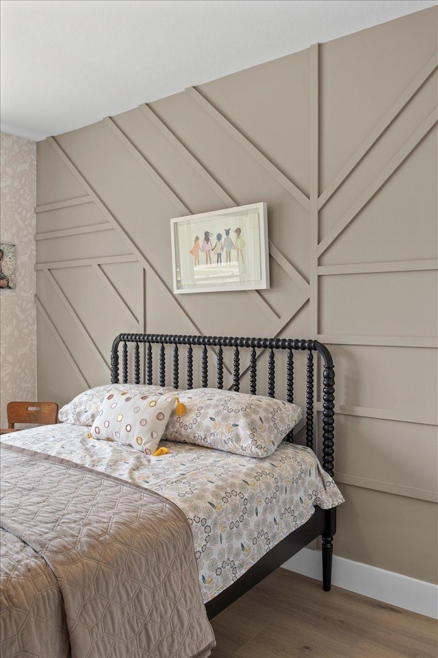 2041 Oak St, Lake City, MN 55041 - bedroom featuring wood finished floors, a decorative wall, and wallpapered walls