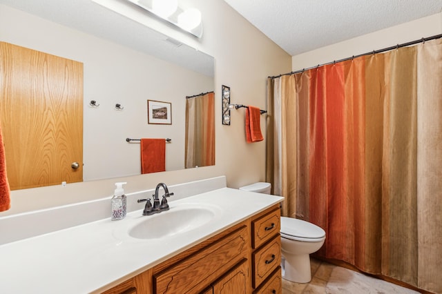 bathroom featuring a textured ceiling, vanity, toilet, and visible vents
