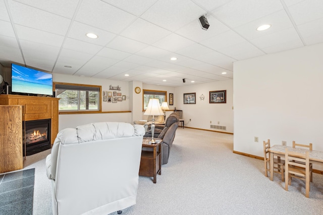living area with visible vents, recessed lighting, carpet floors, and a glass covered fireplace