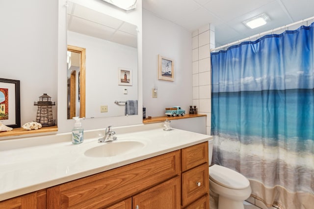 full bathroom with toilet, a drop ceiling, vanity, and a shower with shower curtain