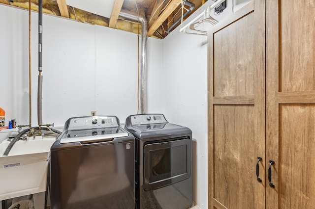 washroom featuring washer and dryer, a sink, and laundry area
