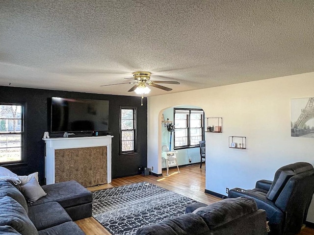 305 Kneale Ave N, Thief River Falls, MN 56701 - living room with arched walkways, a textured ceiling, a ceiling fan, and wood finished floors