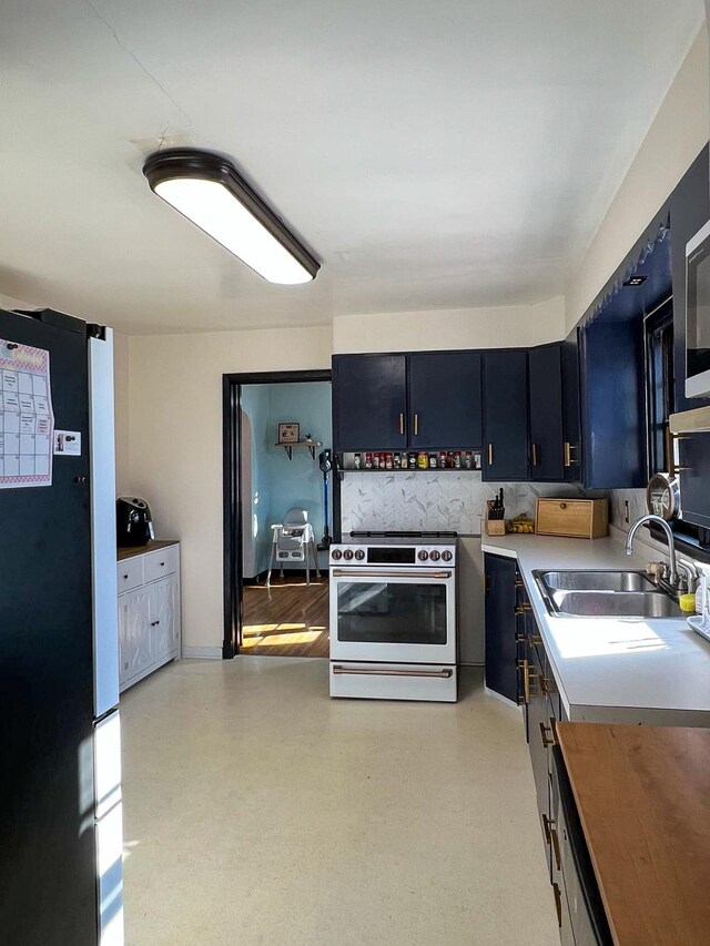 305 Kneale Ave N, Thief River Falls, MN 56701 - kitchen featuring light countertops, freestanding refrigerator, dark cabinetry, a sink, and electric range oven