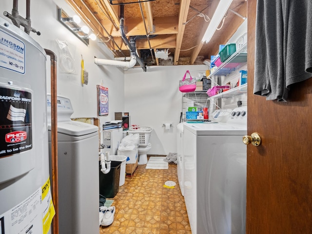 washroom with water heater, washing machine and clothes dryer, light floors, and laundry area