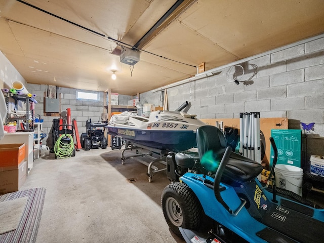 garage with a garage door opener, electric panel, and concrete block wall