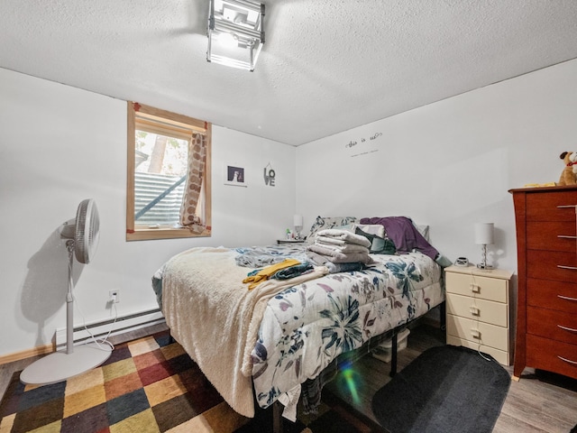 bedroom featuring a textured ceiling, wood finished floors, and baseboard heating