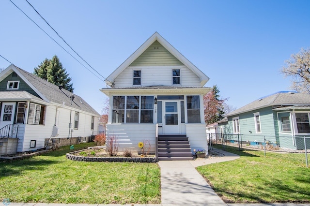 708 1st St N, Fargo, ND 58102 - view of front of house featuring a sunroom, fence, a front yard, and cooling unit