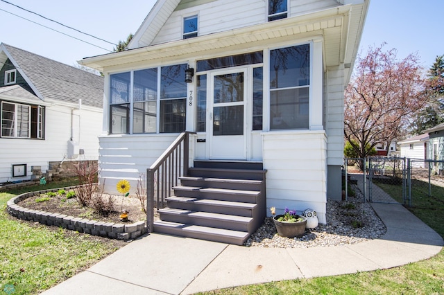 708 1st St N, Fargo, ND 58102 - view of front of home with a sunroom, a gate, fence, and entry steps