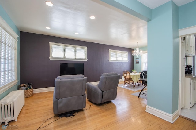 708 1st St N, Fargo, ND 58102 - living room with baseboards, light wood finished floors, a notable chandelier, radiator, and recessed lighting