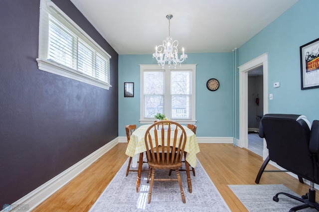 708 1st St N, Fargo, ND 58102 - dining area with an inviting chandelier, baseboards, and light wood-style flooring