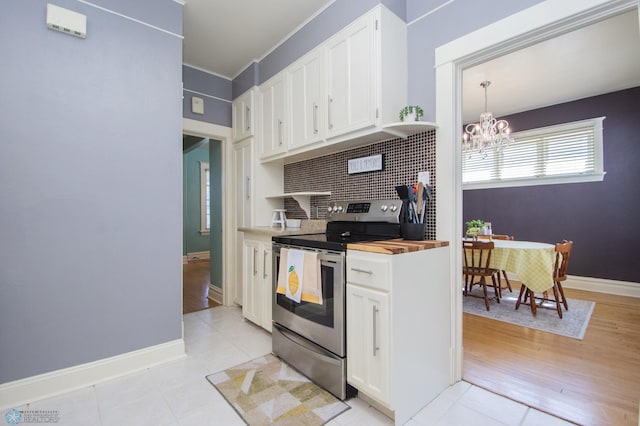708 1st St N, Fargo, ND 58102 - kitchen featuring wooden counters, white cabinetry, stainless steel electric stove, backsplash, and a notable chandelier