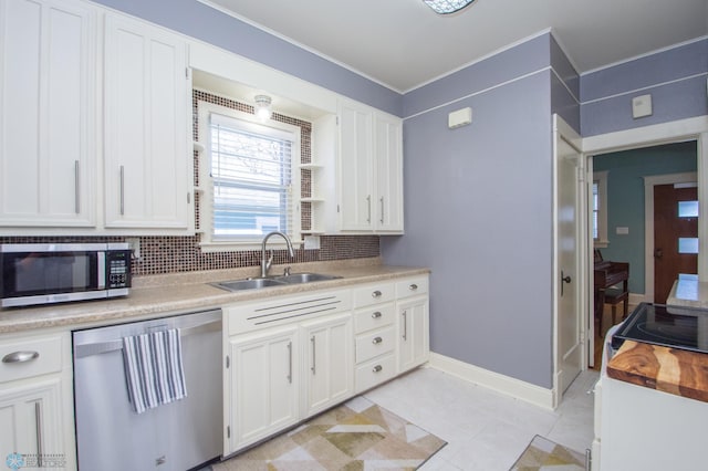 708 1st St N, Fargo, ND 58102 - kitchen featuring backsplash, appliances with stainless steel finishes, a sink, ornamental molding, and white cabinetry
