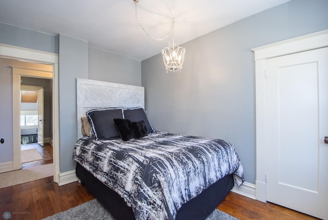 708 1st St N, Fargo, ND 58102 - bedroom with wood-type flooring, baseboards, and a notable chandelier