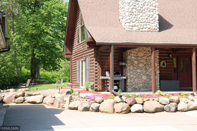 14638 State Highway 70, Pine City, MN 55063 - view of front of home with log exterior, roof with shingles, and a patio