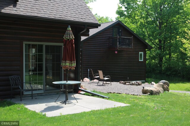 14638 State Highway 70, Pine City, MN 55063 - rear view of house with roof with shingles, a patio area, faux log siding, and a lawn