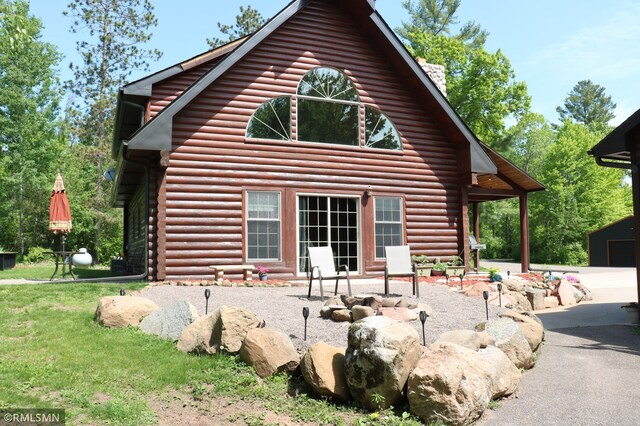 14638 State Highway 70, Pine City, MN 55063 - rear view of house with log exterior and a chimney