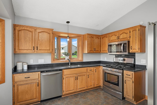 kitchen featuring stainless steel appliances, a textured ceiling, a sink, and lofted ceiling