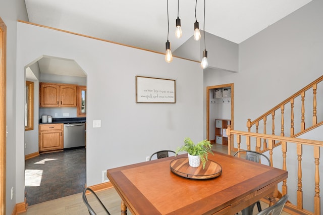 dining area with visible vents, wood finished floors, baseboards, stairway, and arched walkways