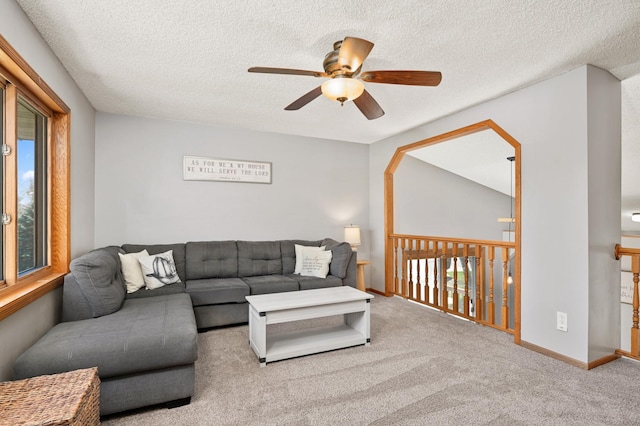 living room featuring carpet floors, ceiling fan, baseboards, and a textured ceiling