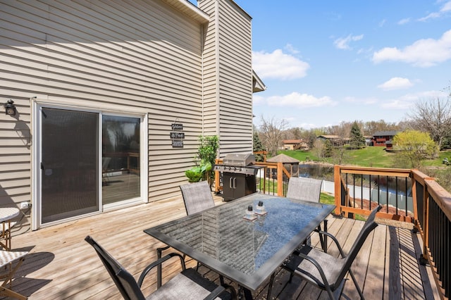 wooden deck with area for grilling, a water view, and outdoor dining area