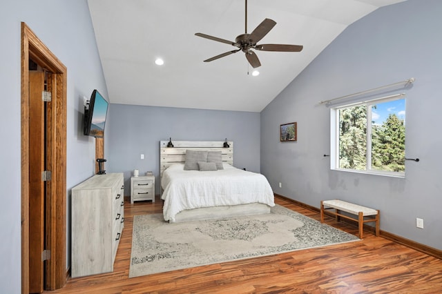 bedroom featuring baseboards, ceiling fan, wood finished floors, and lofted ceiling