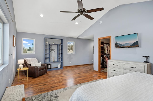 bedroom with recessed lighting, wood finished floors, vaulted ceiling, and a spacious closet