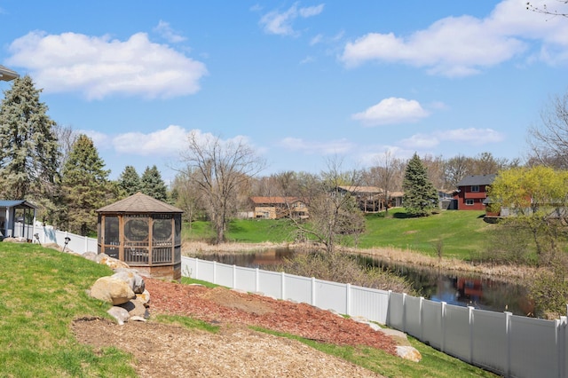 view of yard with a gazebo, a water view, and fence