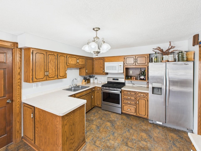 kitchen with stainless steel appliances, a peninsula, brown cabinetry, and a sink