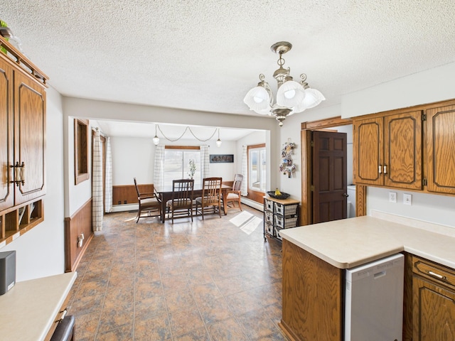 kitchen with dishwasher, light countertops, a chandelier, a textured ceiling, and brown cabinetry