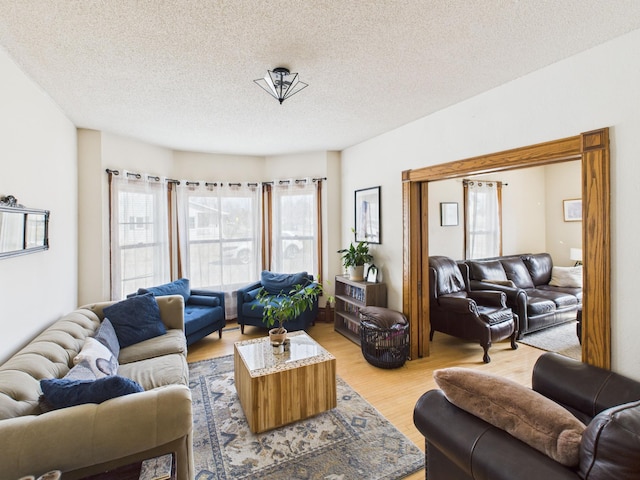 living area with light wood-style flooring and a textured ceiling