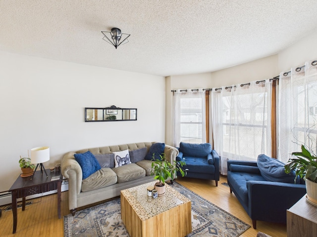 living area featuring a textured ceiling, a baseboard radiator, and light wood-style floors