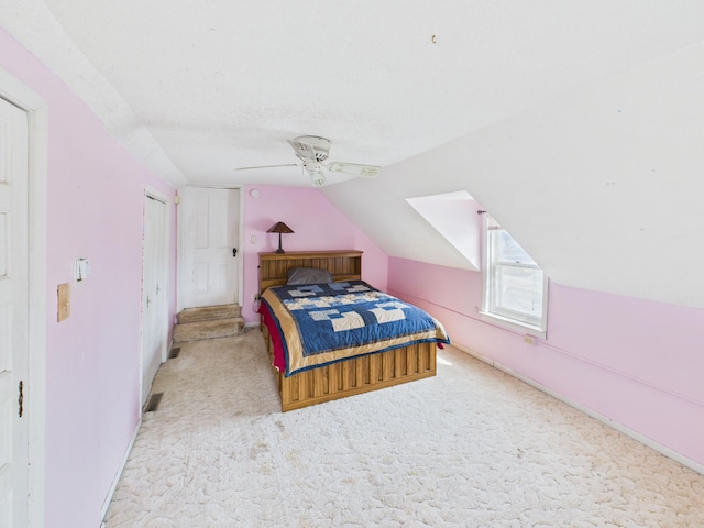 bedroom featuring carpet, a textured ceiling, vaulted ceiling, and a ceiling fan
