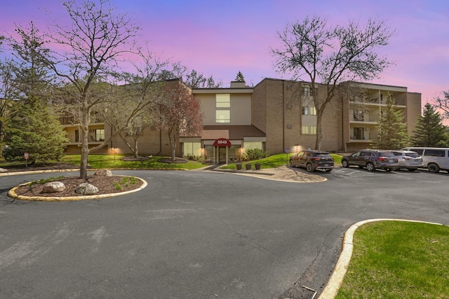 property at dusk with uncovered parking
