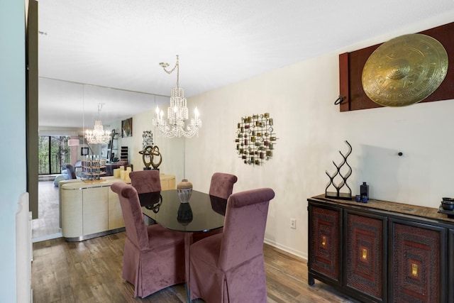 dining room with a chandelier, wood finished floors, and baseboards