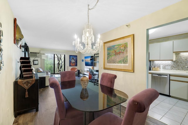 dining area featuring a chandelier, light wood-style floors, and baseboards