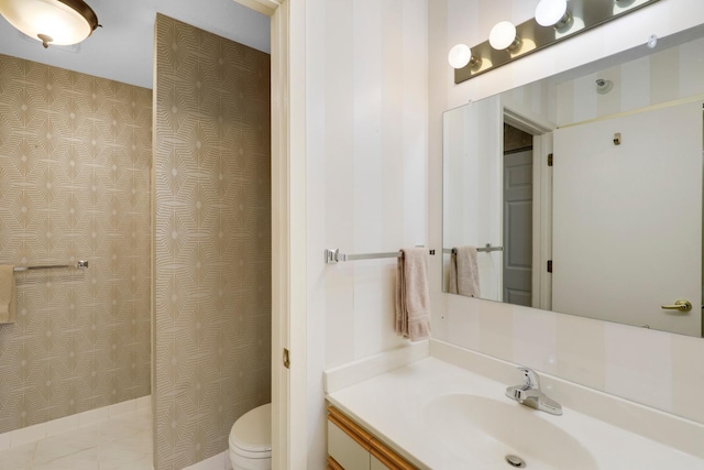 full bath with toilet, vanity, and wallpapered walls