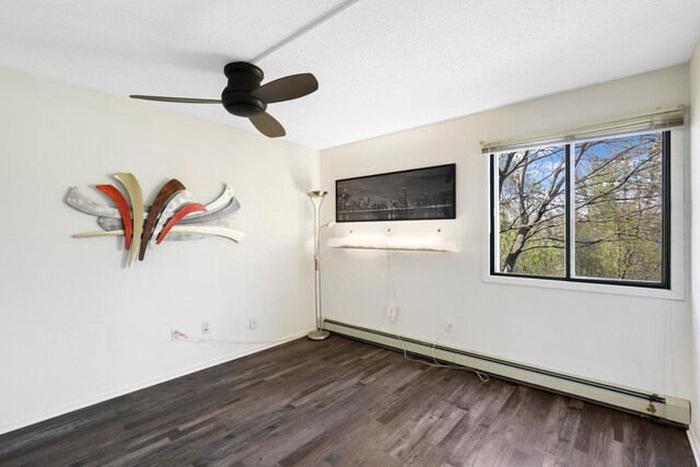 empty room with a baseboard heating unit, wood finished floors, a ceiling fan, and a textured ceiling