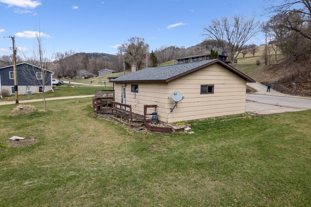 view of side of property featuring a chimney and a yard