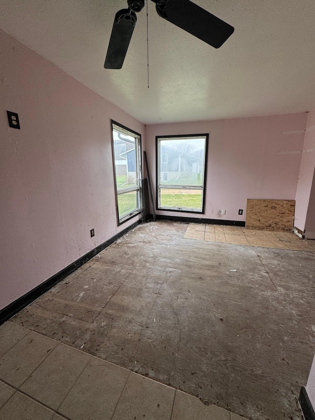 spare room featuring baseboards and ceiling fan