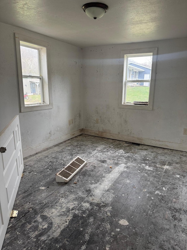 spare room with a wealth of natural light and visible vents