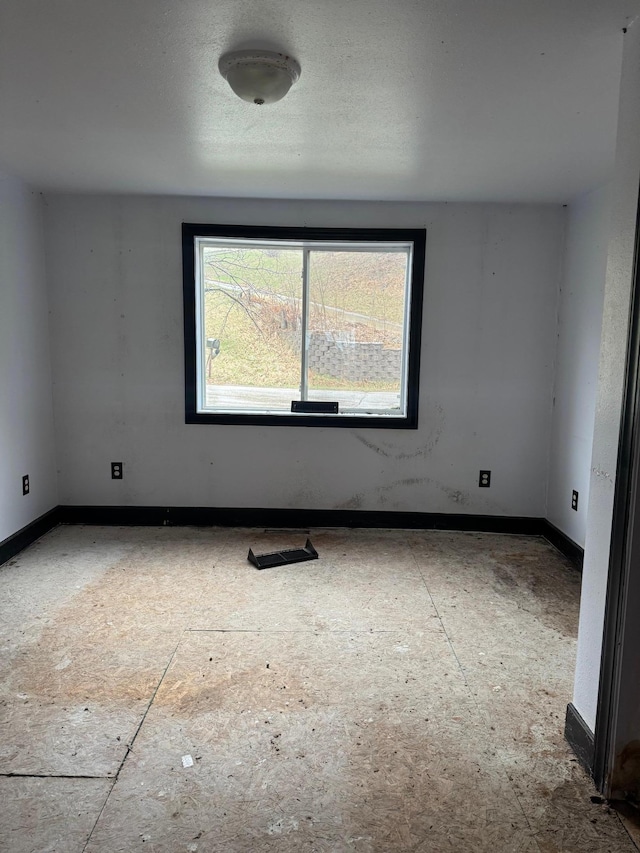 spare room with baseboards