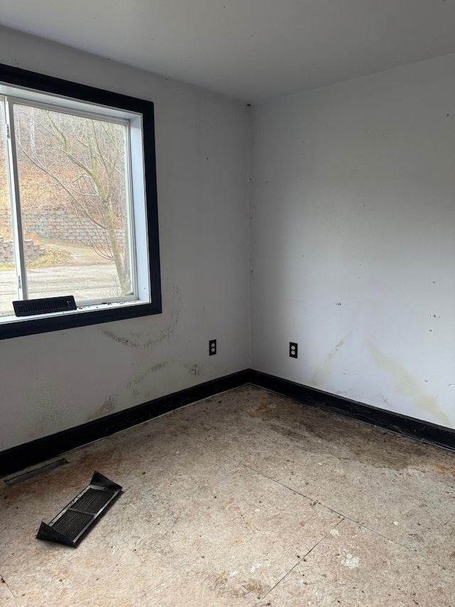 unfurnished room with baseboards and visible vents