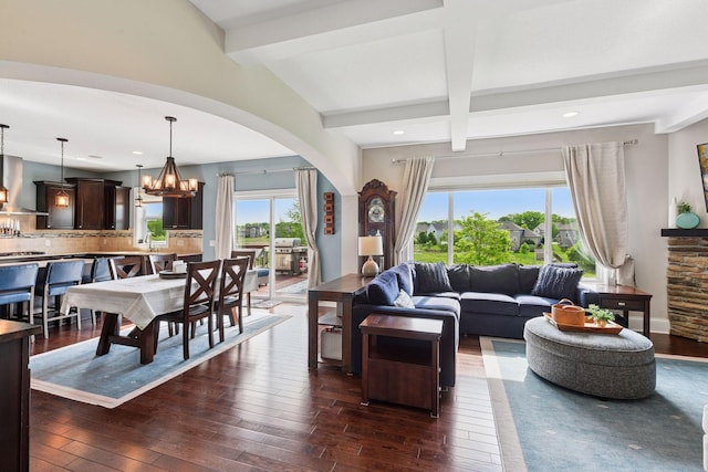 3209 Symphony Ct, Chaska, MN 55318 - living room featuring arched walkways, dark wood-style floors, beamed ceiling, a chandelier, and recessed lighting