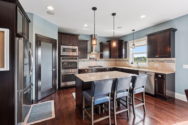 3209 Symphony Ct, Chaska, MN 55318 - kitchen featuring stainless steel appliances, wall chimney exhaust hood, dark brown cabinets, light countertops, and recessed lighting