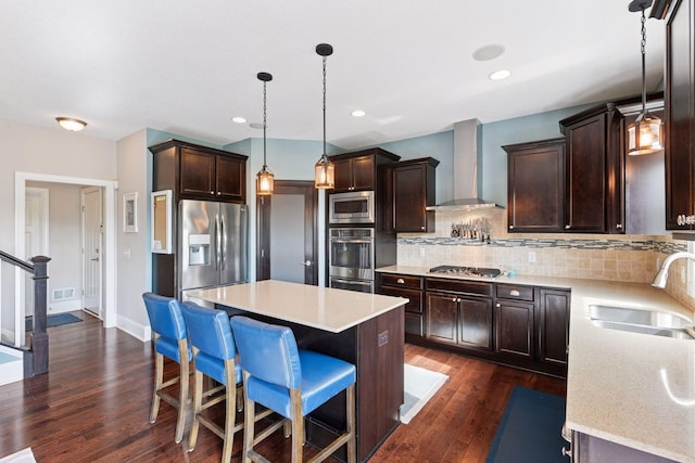 3209 Symphony Ct, Chaska, MN 55318 - kitchen with wall chimney exhaust hood, appliances with stainless steel finishes, dark brown cabinets, dark wood-style flooring, and tasteful backsplash