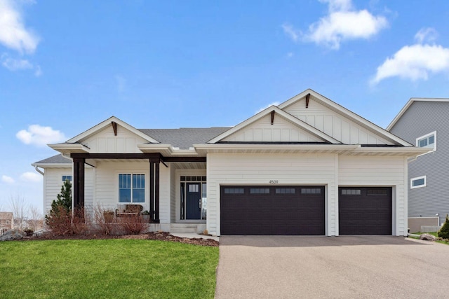 view of front of property featuring a front lawn, driveway, an attached garage, and board and batten siding